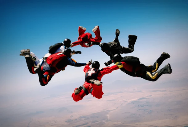 Skydivers jump from an aeroplane, floating through the blue sky, ready to deploy their parachutes