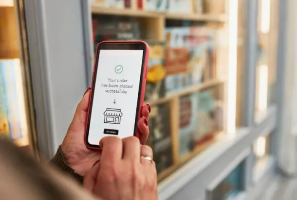 Woman holding a smartphone and placing a currency order online