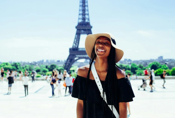 A girl getting photographed in front of the Eiffel Tower in Paris