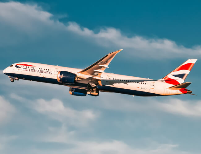 British Airways plane taking off, in mid air under blue sky during daytime